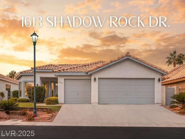 1613 Shadow Rock Dr, Las Vegas, NV 89117 - mediterranean / spanish house with stucco siding, a tiled roof, driveway, and a garage