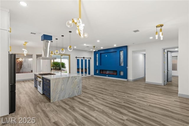 1613 Shadow Rock Dr, Las Vegas, NV 89117 - kitchen with gas range oven, light wood-style floors, recessed lighting, baseboards, and extractor fan