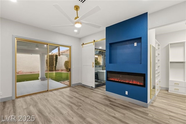 1613 Shadow Rock Dr, Las Vegas, NV 89117 - unfurnished living room featuring wood finished floors, a fireplace, ceiling fan, a barn door, and baseboards