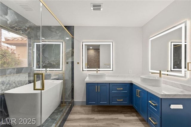 1613 Shadow Rock Dr, Las Vegas, NV 89117 - full bath with double vanity, a soaking tub, a shower stall, and wood finished floors