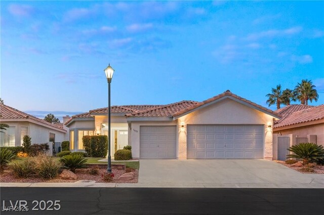 1613 Shadow Rock Dr, Las Vegas, NV 89117 - view of front of house with an attached garage, concrete driveway, a tiled roof, and stucco siding