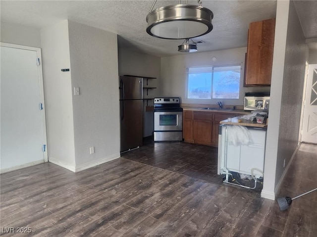 781 Buol Rd, Pahrump, NV 89048 - kitchen featuring appliances with stainless steel finishes, brown cabinetry, dark wood-type flooring, a textured wall, and a textured ceiling