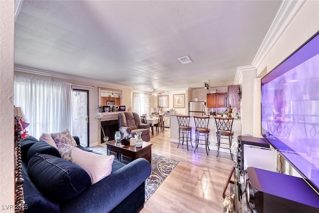 4050 Pacific Harbors Dr Unit 107, Las Vegas, NV 89121 - living room featuring crown molding, light wood finished floors, and ceiling fan