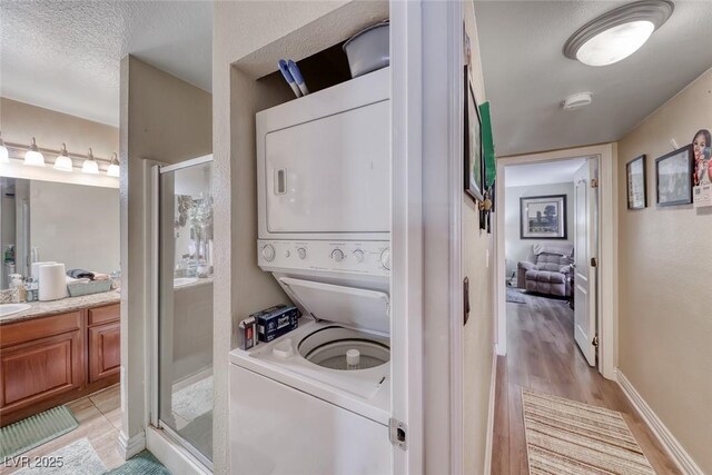 4050 Pacific Harbors Dr Unit 107, Las Vegas, NV 89121 - washroom with stacked washer / dryer, light wood finished floors, and baseboards