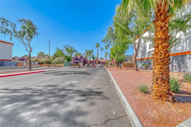 4050 Pacific Harbors Dr Unit 107, Las Vegas, NV 89121 - view of asphalt road with curbs, street lights, and sidewalks