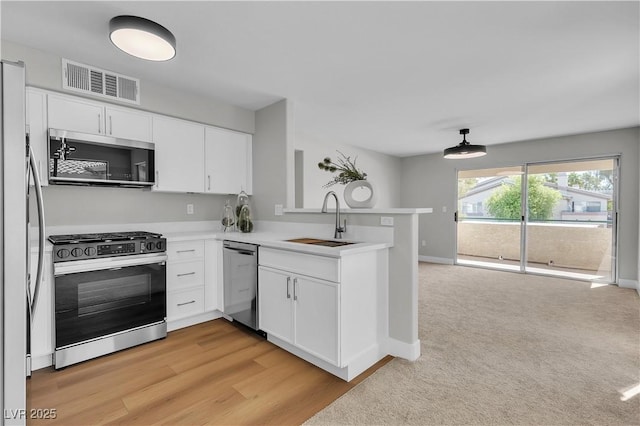 5710 E Tropicana Ave Unit 2152, Las Vegas, NV 89122 - kitchen featuring stainless steel appliances, a sink, a peninsula, white cabinetry, and light countertops
