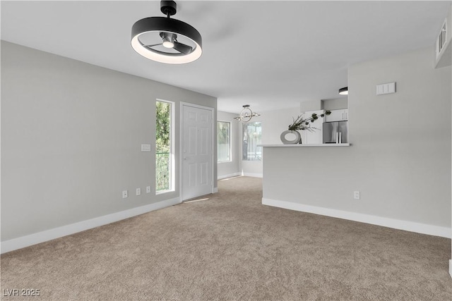 5710 E Tropicana Ave Unit 2152, Las Vegas, NV 89122 - unfurnished living room featuring carpet flooring, a chandelier, and baseboards
