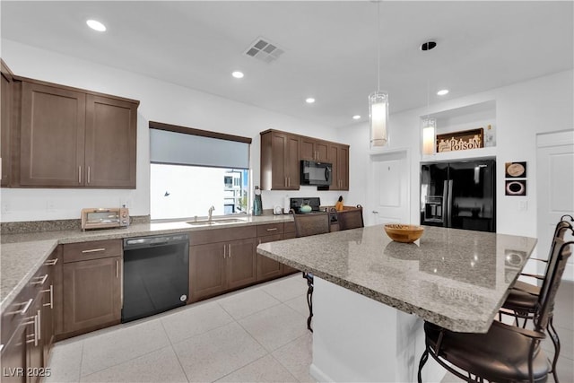 8178 Eaton Hill St, Las Vegas, NV 89113 - kitchen featuring black appliances, a breakfast bar, a kitchen island, recessed lighting, and decorative light fixtures