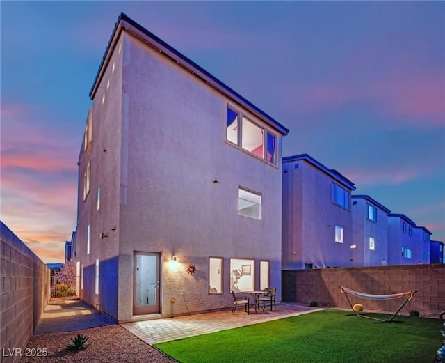 8178 Eaton Hill St, Las Vegas, NV 89113 - back of property at dusk with a patio area, stucco siding, and a fenced backyard