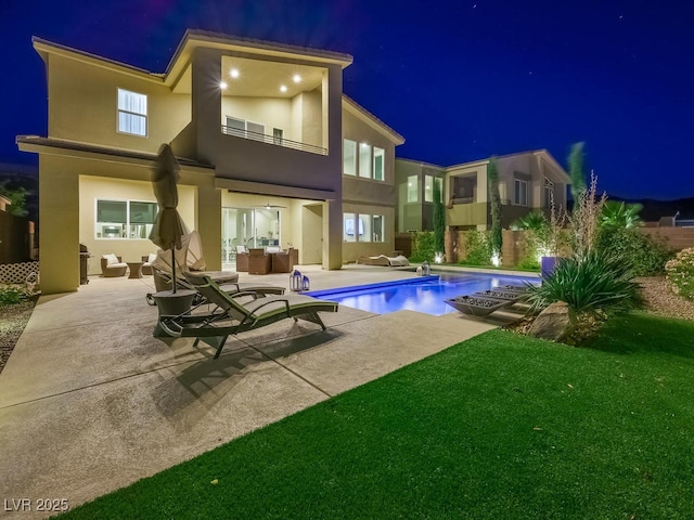 3 Hilltop Crest St, Henderson, NV 89011 - back of house at twilight with an outdoor hangout area, stucco siding, a patio area, a balcony, and an outdoor pool