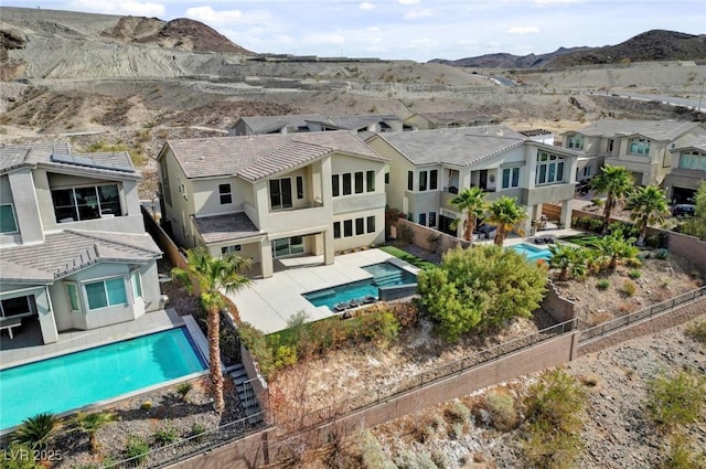 3 Hilltop Crest St, Henderson, NV 89011 - rear view of property featuring a residential view, a fenced backyard, stucco siding, a mountain view, and a pool with connected hot tub