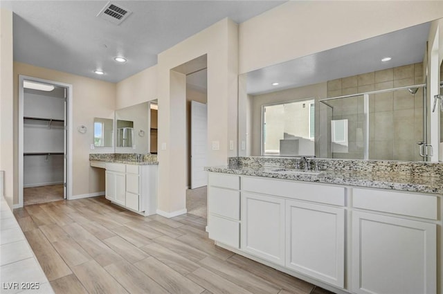 3 Hilltop Crest St, Henderson, NV 89011 - full bath featuring a shower stall, baseboards, wood finished floors, two vanities, and a spacious closet