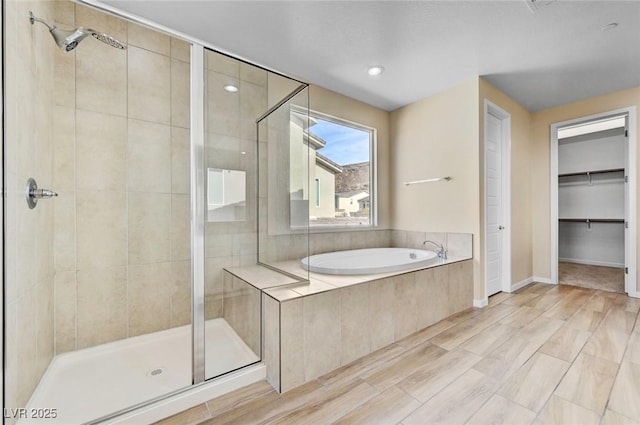 3 Hilltop Crest St, Henderson, NV 89011 - full bathroom with a stall shower, a garden tub, a walk in closet, wood finished floors, and baseboards