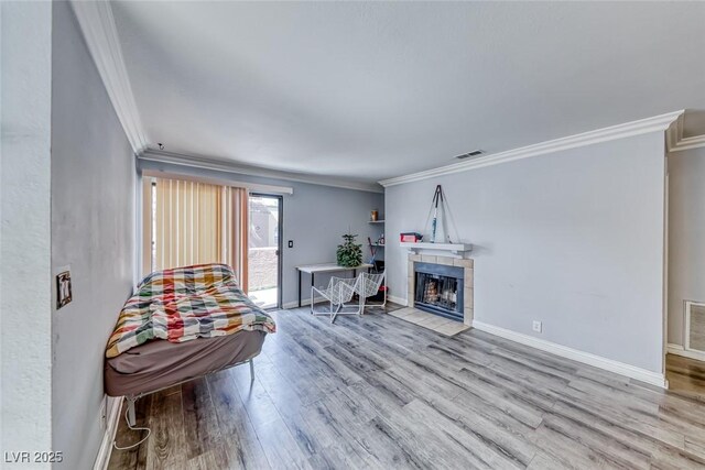 4050 Pacific Harbors Dr Unit 245, Las Vegas, NV 89121 - living area featuring ornamental molding, wood finished floors, baseboards, and a tiled fireplace