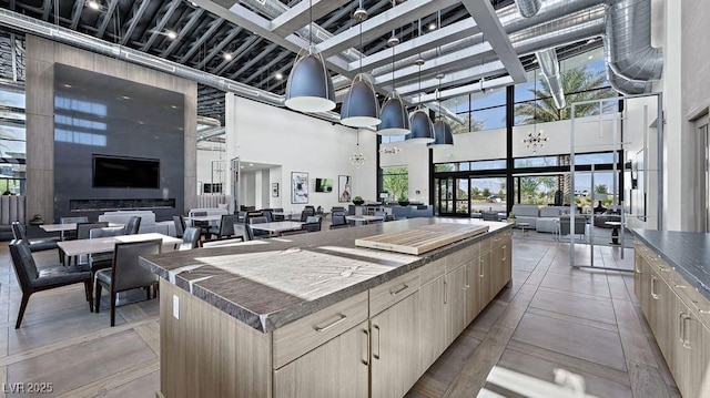 4200 E Brusca Way, Pahrump, NV 89061 - kitchen with a high ceiling, a center island, open floor plan, plenty of natural light, and dark countertops