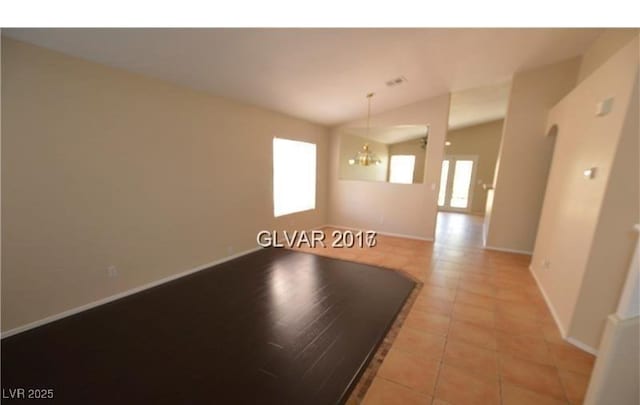 7518 Luna Del Rey St, Las Vegas, NV 89123 - unfurnished room featuring light tile patterned floors, lofted ceiling, baseboards, and a chandelier