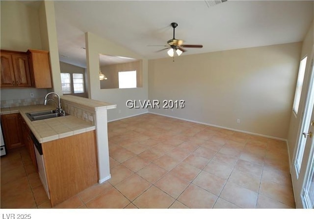 7518 Luna Del Rey St, Las Vegas, NV 89123 - kitchen featuring a sink, tile countertops, a ceiling fan, lofted ceiling, and brown cabinets