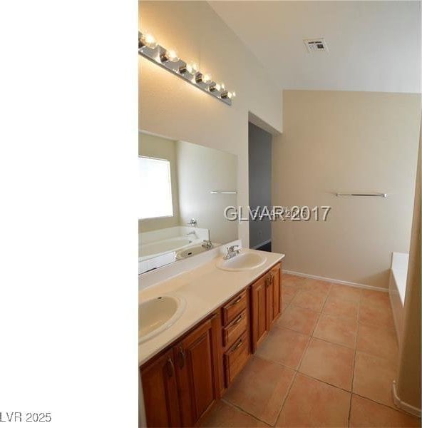 7518 Luna Del Rey St, Las Vegas, NV 89123 - bathroom featuring a bathtub, tile patterned flooring, and double vanity