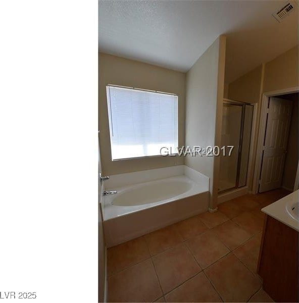 7518 Luna Del Rey St, Las Vegas, NV 89123 - bathroom featuring tile patterned flooring, a shower stall, a bath, and vanity
