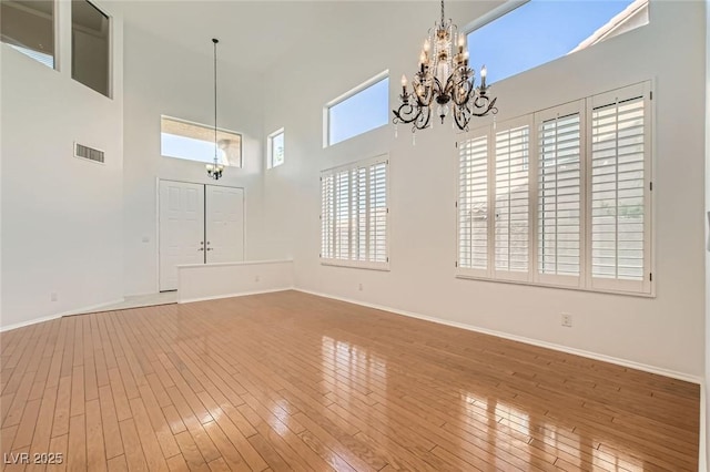 10241 Regents Cross Pl, Las Vegas, NV 89144 - empty room with a chandelier, wood-type flooring, baseboards, and a high ceiling