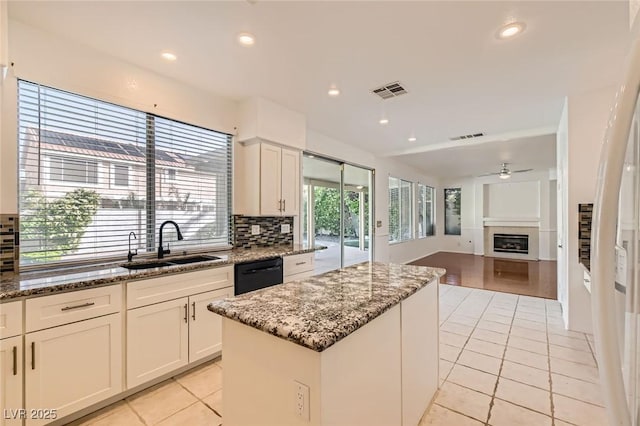 10241 Regents Cross Pl, Las Vegas, NV 89144 - kitchen featuring light tile patterned floors, a sink, dishwasher, backsplash, and a center island