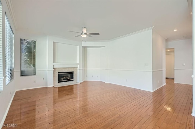 10241 Regents Cross Pl, Las Vegas, NV 89144 - unfurnished living room featuring ceiling fan, a fireplace, light wood-style floors, crown molding, and baseboards