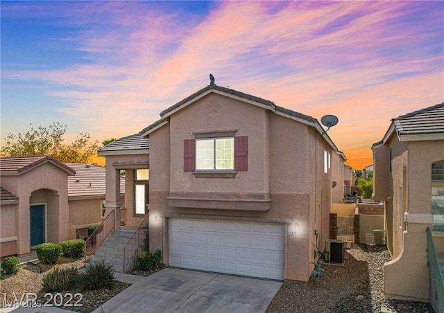 4507 Grotto Ct, North Las Vegas, NV 89031 - view of front of home featuring an attached garage, stucco siding, concrete driveway, and cooling unit