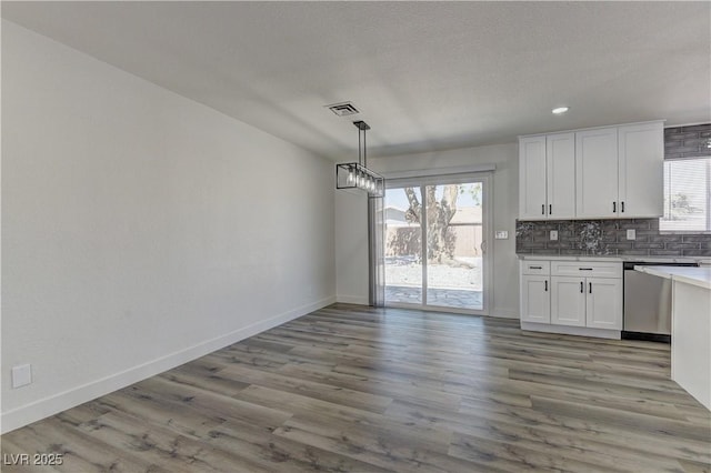1901 Farnam Pl, Las Vegas, NV 89102 - kitchen featuring dishwasher, white cabinets, tasteful backsplash, light countertops, and baseboards