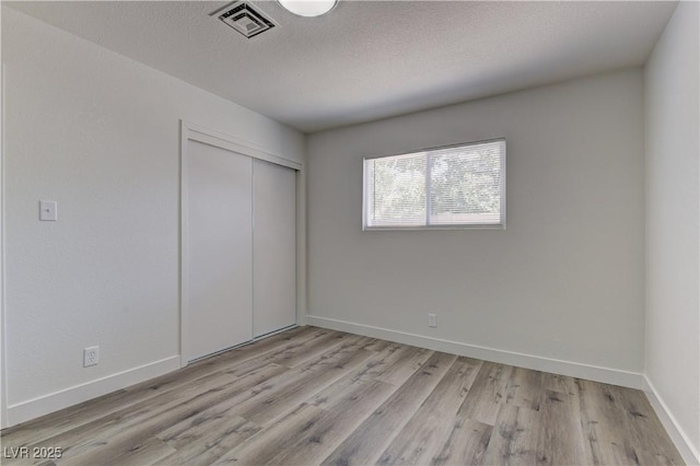 1901 Farnam Pl, Las Vegas, NV 89102 - unfurnished bedroom with light wood-style flooring, a closet, baseboards, and a textured ceiling