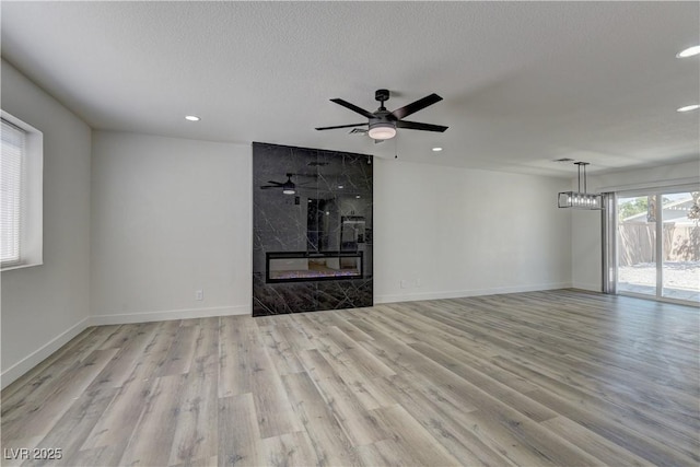 1901 Farnam Pl, Las Vegas, NV 89102 - unfurnished living room with wood finished floors, recessed lighting, baseboards, a premium fireplace, and a ceiling fan