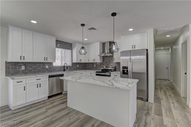 1901 Farnam Pl, Las Vegas, NV 89102 - kitchen with stainless steel appliances, wall chimney range hood, a sink, white cabinetry, and recessed lighting