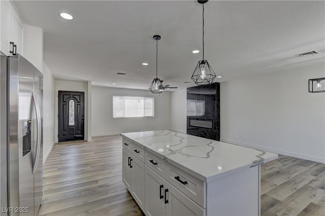 1901 Farnam Pl, Las Vegas, NV 89102 - kitchen with stainless steel fridge, open floor plan, light wood-style floors, recessed lighting, and white cabinetry