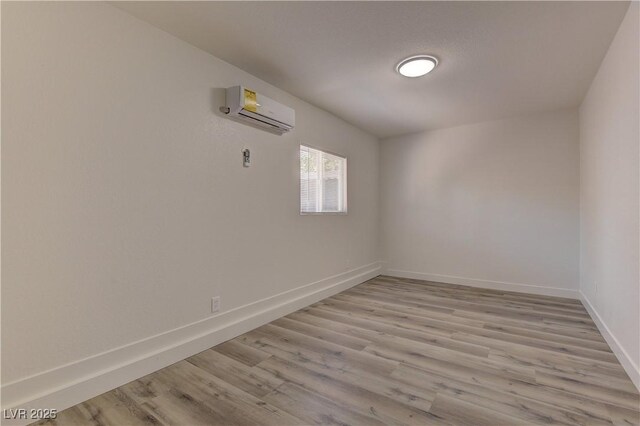 1901 Farnam Pl, Las Vegas, NV 89102 - spare room with a wall unit AC, baseboards, and light wood-style flooring