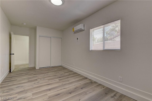 1901 Farnam Pl, Las Vegas, NV 89102 - unfurnished bedroom with a wall mounted air conditioner, baseboards, light wood-style flooring, and a closet