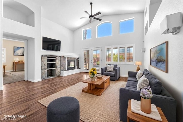 1088 Casady Hollow Ave, Henderson, NV 89012 - living area featuring ceiling fan, wood finished floors, high vaulted ceiling, a fireplace, and baseboards