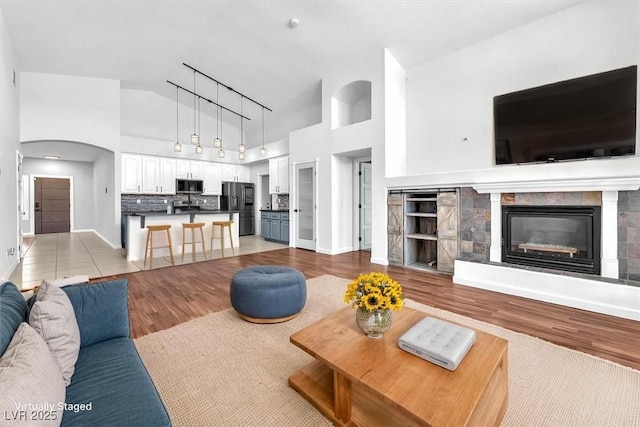 1088 Casady Hollow Ave, Henderson, NV 89012 - living area featuring light wood finished floors, high vaulted ceiling, and a tile fireplace