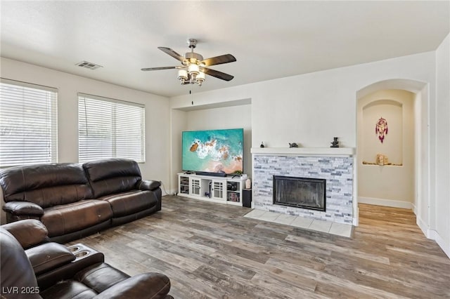 564 Lampshire Ln, Pahrump, NV 89060 - living area with ceiling fan, wood finished floors, a stone fireplace, and baseboards