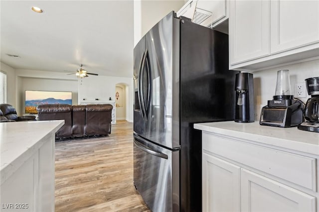 564 Lampshire Ln, Pahrump, NV 89060 - kitchen featuring stainless steel fridge, white cabinetry, light wood-style floors, a ceiling fan, and light stone countertops
