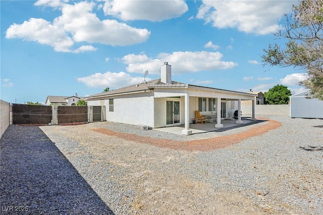 564 Lampshire Ln, Pahrump, NV 89060 - back of property with a patio, a fenced backyard, a chimney, and stucco siding