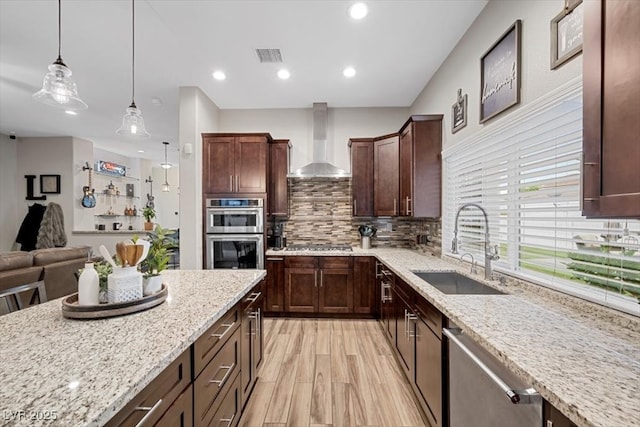 219 Windsong Dr, Henderson, NV 89074 - kitchen featuring wall chimney range hood, a sink, appliances with stainless steel finishes, light stone countertops, and recessed lighting