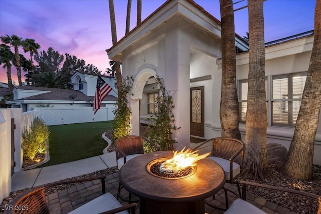 219 Windsong Dr, Henderson, NV 89074 - patio terrace at dusk featuring an outdoor fire pit, a patio, and a lawn