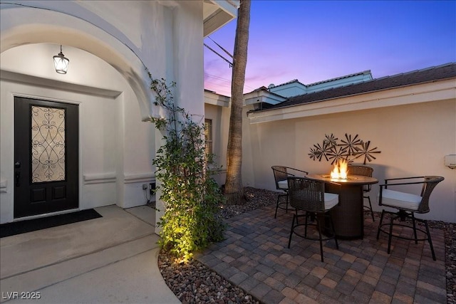 219 Windsong Dr, Henderson, NV 89074 - exterior entry at dusk featuring a patio and stucco siding