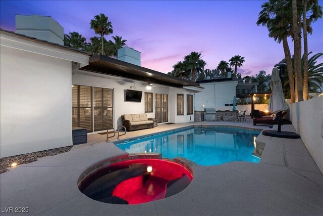219 Windsong Dr, Henderson, NV 89074 - view of swimming pool with an outdoor hangout area, a patio, a pool with connected hot tub, an outdoor kitchen, and a fenced backyard