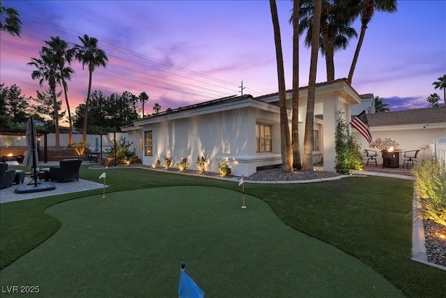 219 Windsong Dr, Henderson, NV 89074 - view of front of property featuring a putting area, a patio area, an outdoor fire pit, and stucco siding