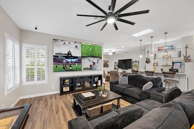 219 Windsong Dr, Henderson, NV 89074 - living room with a ceiling fan, wood finished floors, baseboards, and a skylight
