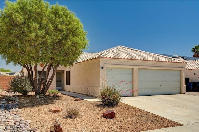 1902 Panther Pl, North Las Vegas, NV 89031 - view of front of home featuring a garage, a tile roof, driveway, and stucco siding