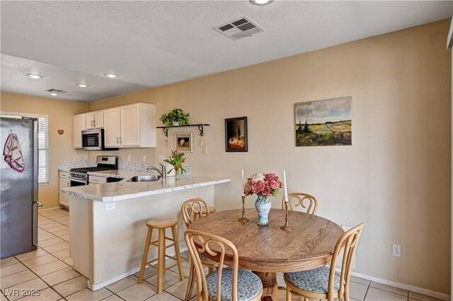1902 Panther Pl, North Las Vegas, NV 89031 - dining room featuring light tile patterned floors, a textured ceiling, baseboards, and recessed lighting