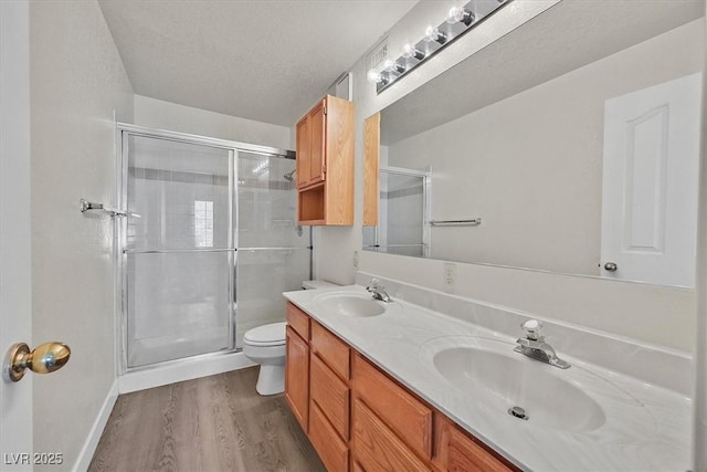2633 S Durango Dr Unit 204, Las Vegas, NV 89117 - full bath with a shower stall, wood finished floors, toilet, double vanity, and baseboards
