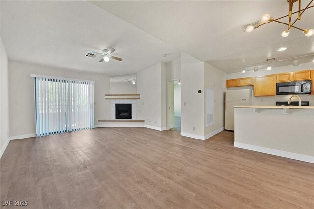 2633 S Durango Dr Unit 204, Las Vegas, NV 89117 - unfurnished living room with a ceiling fan, baseboards, light wood-type flooring, and a sink