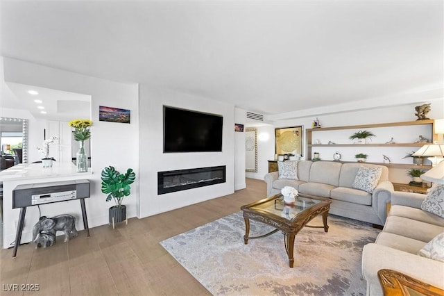 3111 Bel Air Dr Unit 7F, Las Vegas, NV 89109 - living area with wood finished floors and a glass covered fireplace